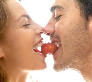 couple biting into a strawberry